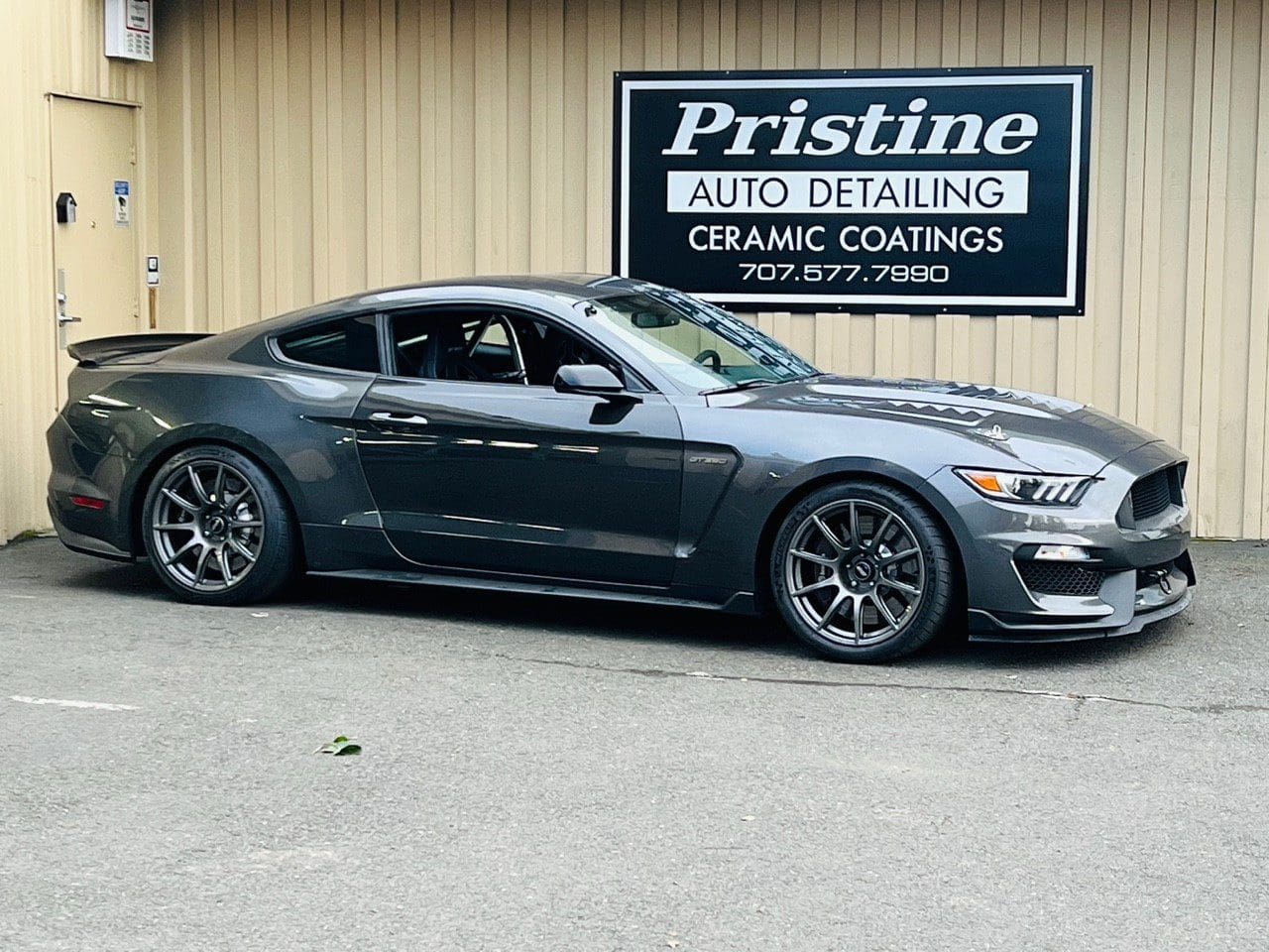 Gray sports car parked outside of auto detailing shop