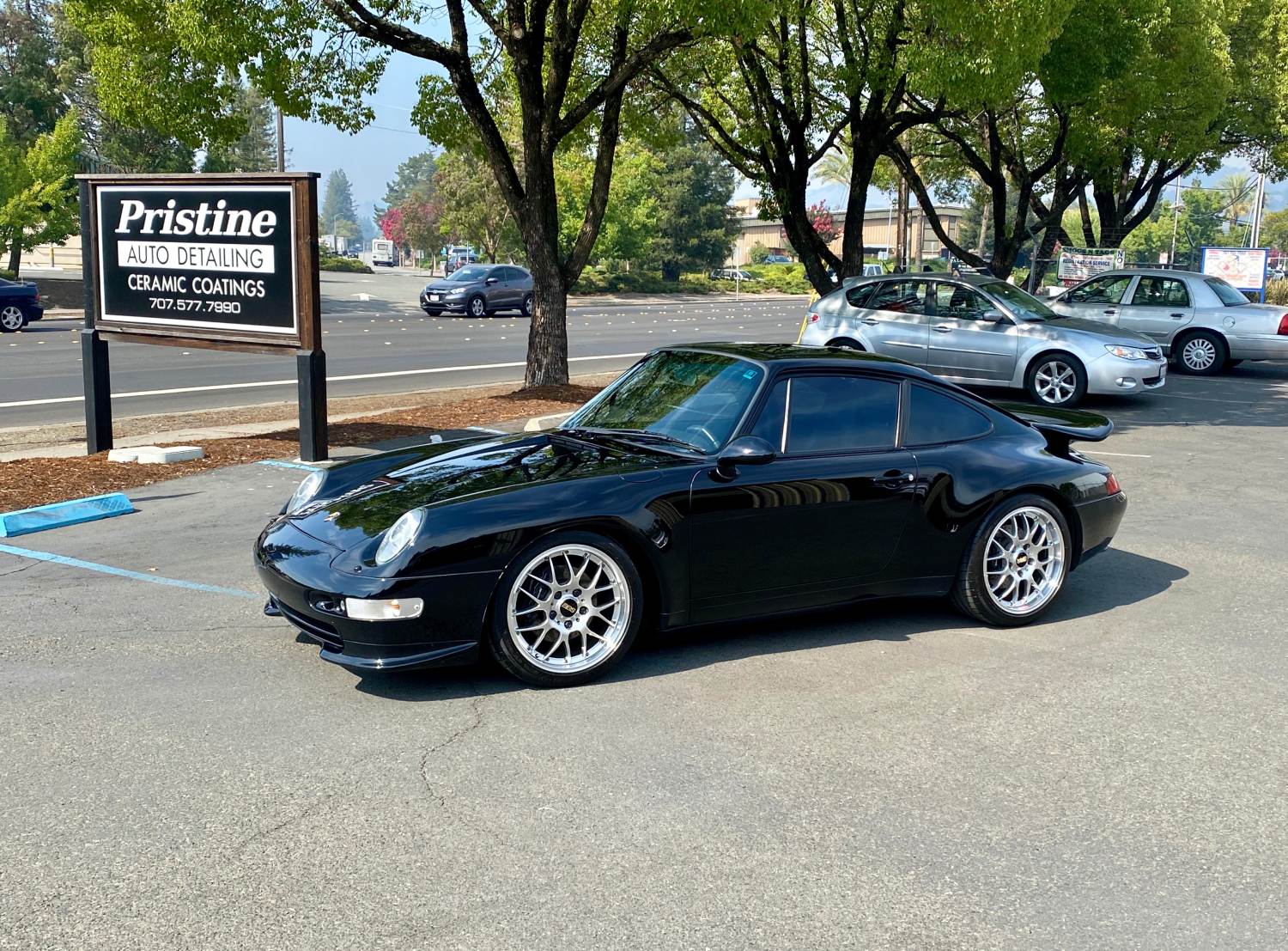 Ceramic Coated Black Porsche 911 parked by detailing shop